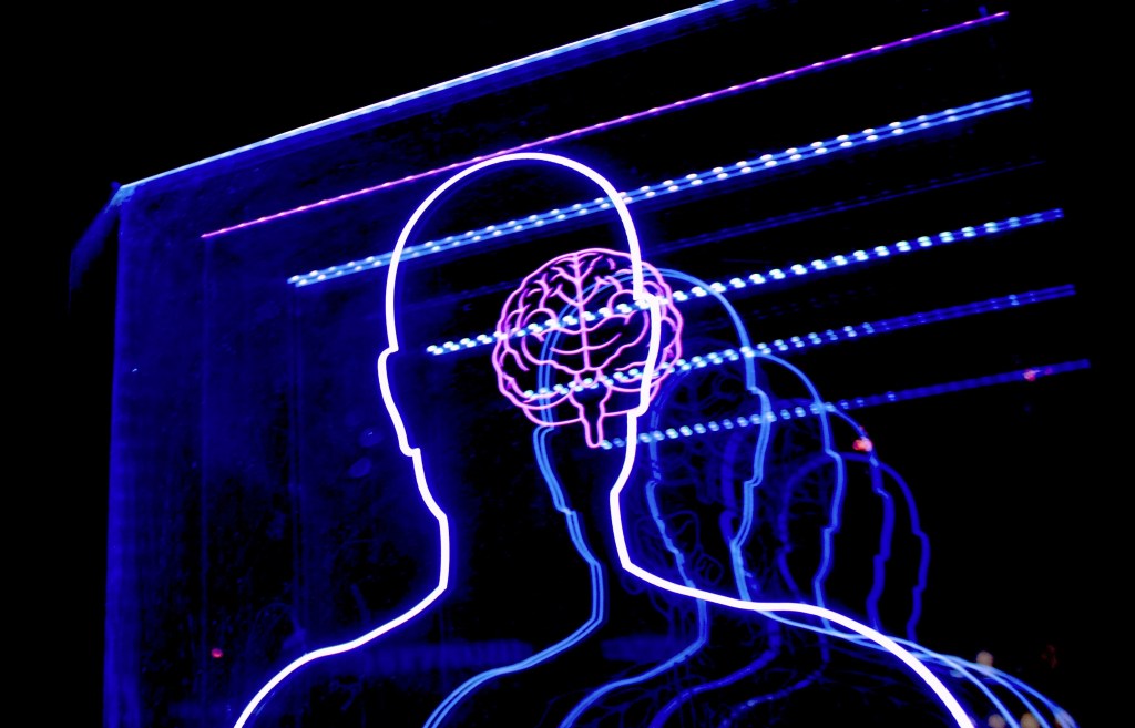Neon lights showing outline of a brain and an upper body