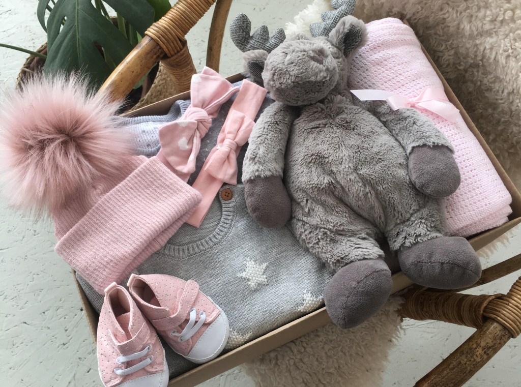 Pink and grey baby items in a box